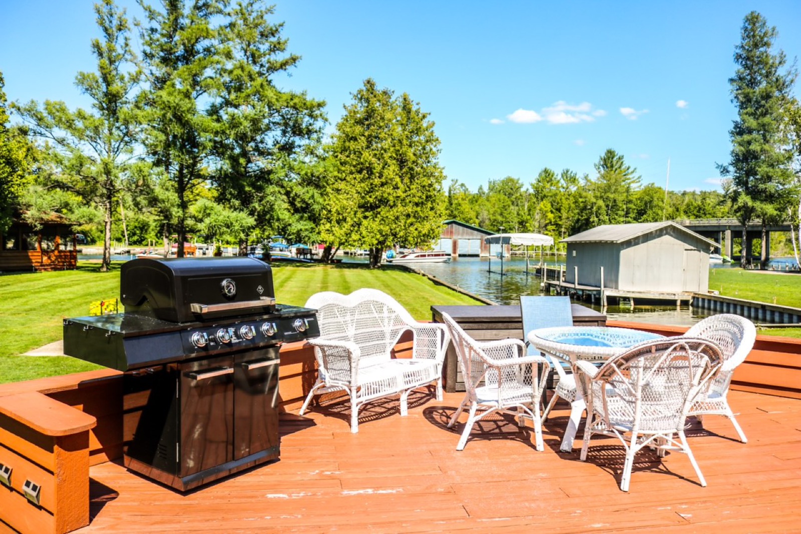 Waterfront deck with seating and grill at The Boathouse on Torch Lake